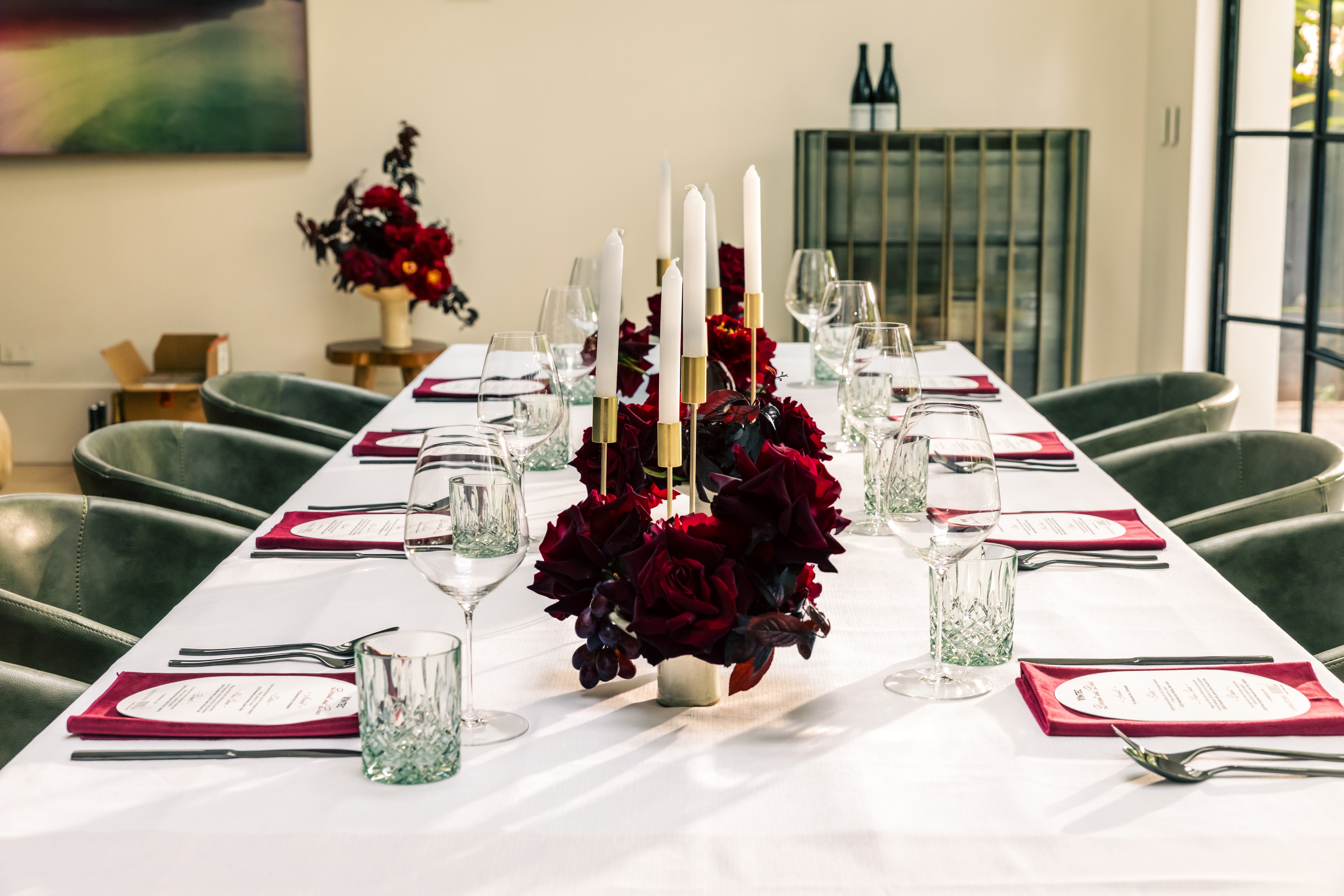 Formal dining setup with candles, wine glasses, floral centerpiece and menu